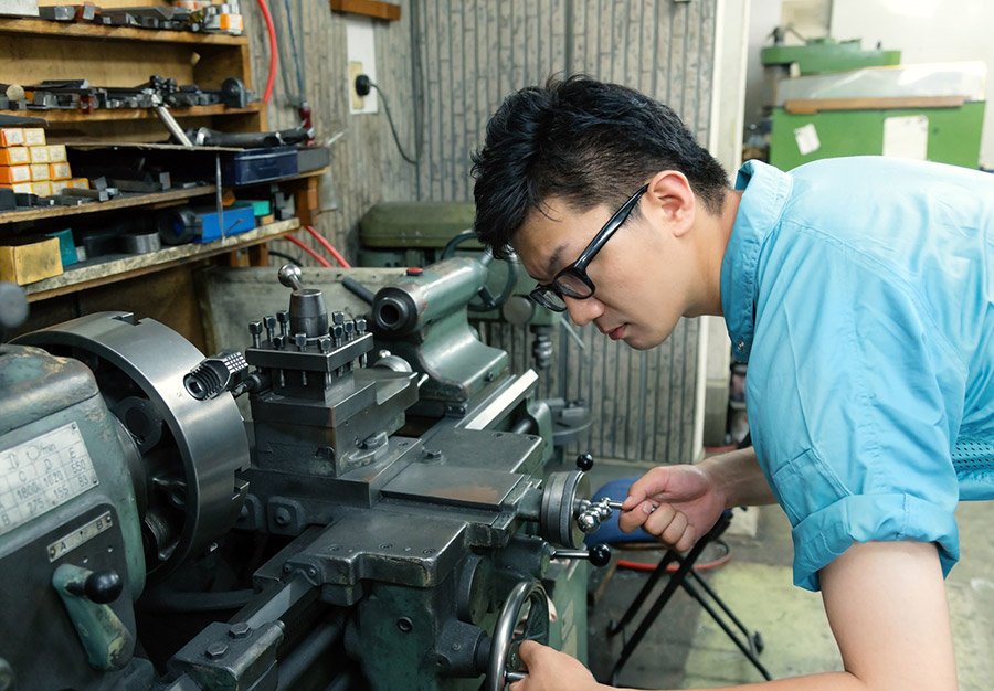 工場で機械を操作する男性