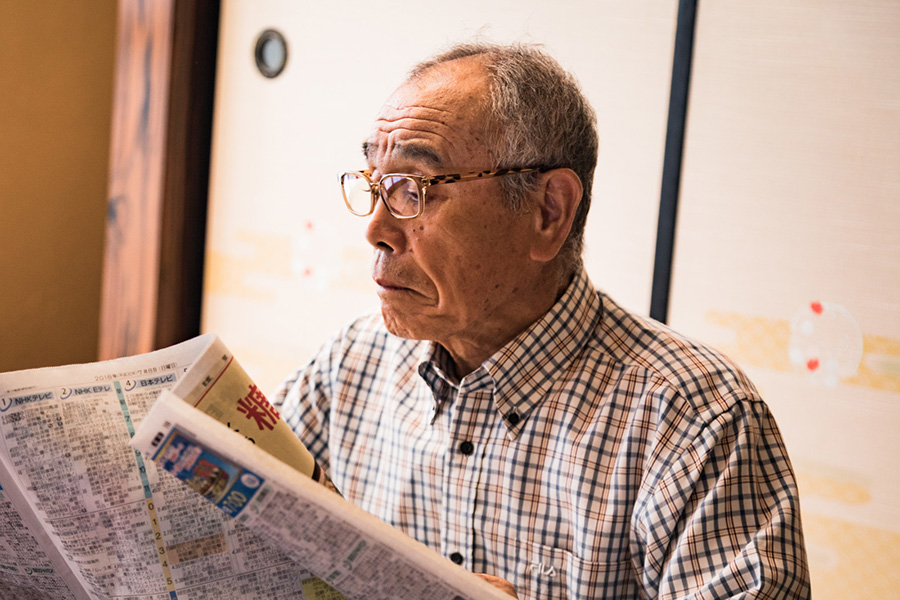 新聞を眺める年配の男性